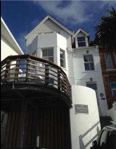 a white house with a wooden fence in front of it at The White House Hotel in Newquay
