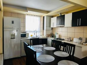 a kitchen with a table and a white refrigerator at IANIS Apartment in Orăştie