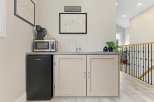 a kitchen with a black refrigerator and a microwave at Redwood Suite - NOTL Prime Location GETAWAY in Niagara-on-the-Lake