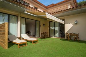 a patio with two chairs and a table on grass at Nou Sol Solet in Begur