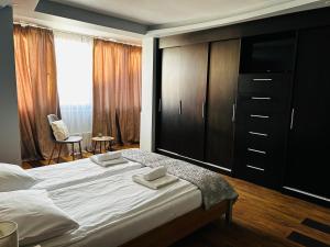 a bedroom with a large bed and a large dresser at IANIS Apartment in Orăştie +1 photo
