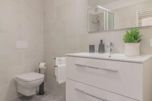 a white bathroom with a toilet and a sink at La Casetta di Lillie in Lierna