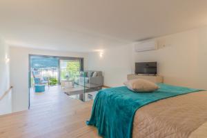a bedroom with a bed and a living room at La Casetta di Lillie in Lierna