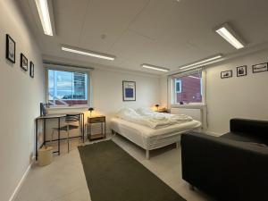 a bedroom with a bed and a table and a couch at Uka Guesthouse Downtown in Nuuk