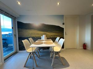 a dining room with a table and white chairs at Uka Guesthouse Downtown in Nuuk