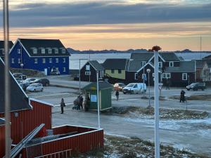 a town with houses and people walking in the street at Uka Guesthouse Downtown in Nuuk +14 photos