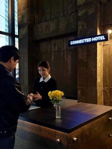 a man and a woman standing next to a table at Connected Hotel Guro in Seoul