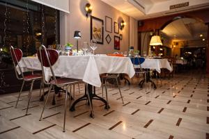 a dining room with white tables and chairs at Hotel Brixellum in Brescello