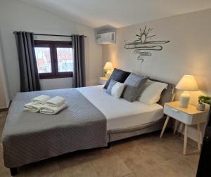 a bedroom with a large bed with towels on it at Teo`s Seaview Specious Apartment, Nikiti near Harbor in Nikiti