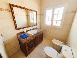 a bathroom with a sink and a toilet and a mirror at Apartamentos Graciosamar in Caleta de Sebo +65 photos