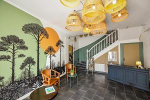 a lobby with a mural of trees on the wall at Hotel Le Coureau in Saint-Trojan-les-Bains