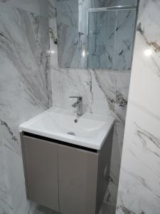 a white bathroom with a sink and a mirror at Chryso Apts Protaras in Protaras +27 photos