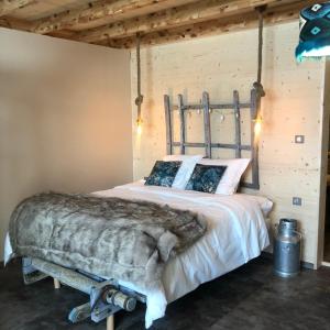 a bed in a room with a wooden wall at Forest d' ARTO in Ancelle