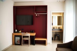 a living room with a table and a tv on a wall at La Casa di Hera in Crotone