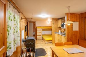 a small room with a dining table and a kitchen at Sruby Peřeje in Ostravice
