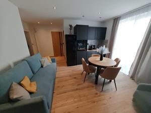 a living room with a blue couch and a table at Apartament WLK HOUSE in Gdynia