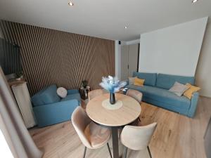 a living room with a table and a blue couch at Apartament WLK HOUSE in Gdynia