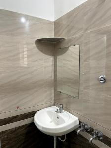 a bathroom with a sink and a mirror at Mango tree room stay in Gokarna