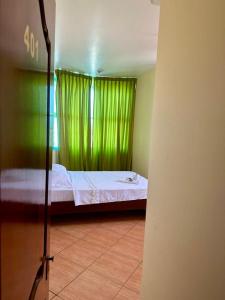 a bedroom with a bed with a green curtain at Hospedaje El Imperio in Tarapoto