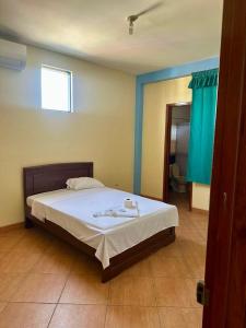 a bedroom with a large bed with white sheets at Hospedaje El Imperio in Tarapoto