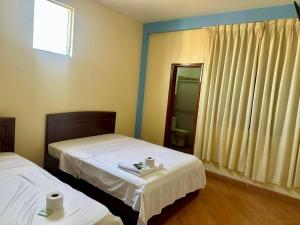 a hotel room with two beds and a window at Hospedaje El Imperio in Tarapoto
