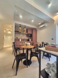 a dining room with tables and chairs and a kitchen at La Casa di Hera in Crotone