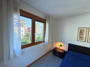 a bedroom with a blue bed and a window at Appartamenti La Croma in Grado