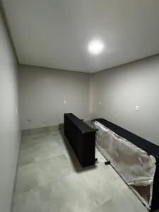an empty room with a black couch in a room at Sobrado Oliveira in Goiânia