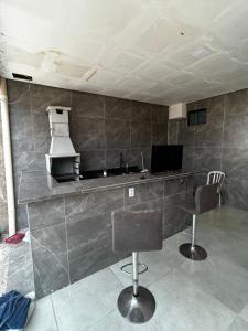 a kitchen with two chairs and a counter top at Sobrado Oliveira in Goiânia