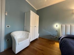 a bedroom with a white chair and a white cabinet at "La Sala di Dante" Wi-Fi, Smart Tv, AC, Bagno Privato in Pistoia