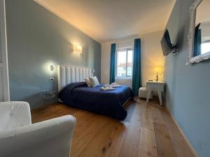 a bedroom with a blue bed and a window at "La Sala di Dante" Wi-Fi, Smart Tv, AC, Bagno Privato in Pistoia