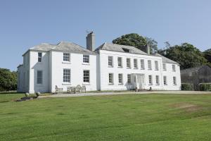 a large white house with a lawn in front of it at Trewardale in Bodmin