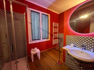a red bathroom with a sink and a shower at "La Sala di Dante" Wi-Fi, Smart Tv, AC, Bagno Privato in Pistoia
