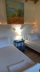 a bedroom with two beds and a table with a lamp at Rizaki Cottage in Nafpaktos in Nafpaktos