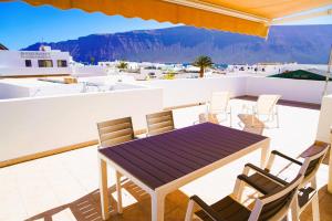 a patio with a table and chairs on a roof at Apartamentos Graciosamar in Caleta de Sebo