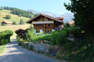 a house on a hill next to a road at Comfortable quiet apartement with great view in Diemtigen