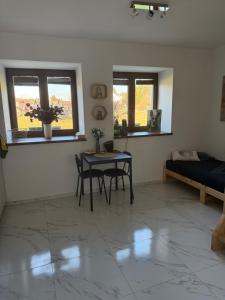 a living room with a table and a bed at Ubytování U Rozárky in Trpnouze