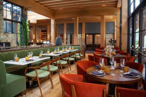 a restaurant with tables and chairs and windows at Delamar Westport in Westport