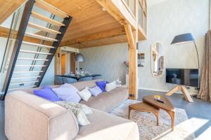 a living room with a couch and a staircase at Buytenplaats Villa 189 in De Koog