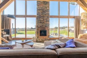 a living room with a couch and a fireplace at Buytenplaats Villa 189 in De Koog