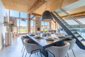 a dining room with a table and chairs and a staircase at Buytenplaats Villa 189 in De Koog