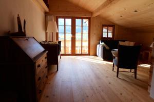 a living room with a wooden floor and a large window at Comfortable quiet apartement with great view in Diemtigen +19 photos