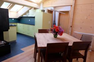 a kitchen with a wooden table with a vase of flowers on it at Comfortable quiet apartement with great view in Diemtigen