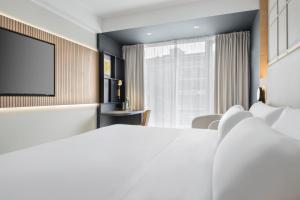 a hotel room with a bed and a tv at Barceló Dresden Newa in Dresden +57 photos