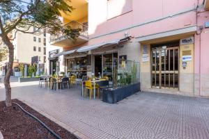 a restaurant with yellow tables and chairs on a sidewalk at Lorixedda Rooms in Quartu SantʼElena