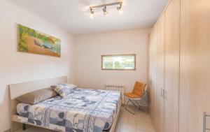 a small bedroom with a bed and a chair at Villa Cambretta con giardino, posto auto e a due passi dal mare in Giannella