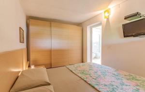 a bedroom with a bed and a tv on the wall at Villa Cambretta con giardino, posto auto e a due passi dal mare in Giannella