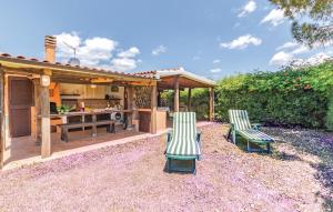 two lawn chairs and a kitchen in a backyard at Villa Cambretta con giardino, posto auto e a due passi dal mare in Giannella