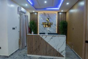 a hotel lobby with a reception desk with a sign at Stallion Luxury Suites in Ado