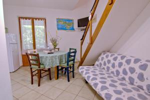 a dining room with a table and chairs and a couch at Casa Gabriella in Fetovaia